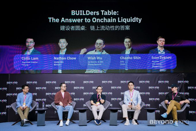 The image features a group of six men sitting around a table, engaged in a discussion about the importance of durable onchain liquidity. The men are seated at a stage with a backdrop that includes text related to the topic they are discussing. The scene suggests an event or gathering where experts and industry professionals come together to share their insights and knowledge about building durable onchain liquidity solutions for various financial markets, such as CeFi, DeFi, and institutional finance.