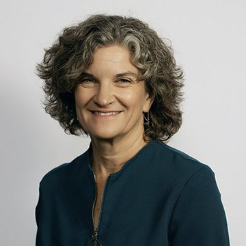 A portrait of a smiling woman with curly gray hair, wearing a dark navy blouse and drop earrings, against a light gray background. The image accompanies a quote from Candace Kelly, Chief Legal Officer of the Stellar Development Foundation, discussing blockchain pilot programs with the UNDP.