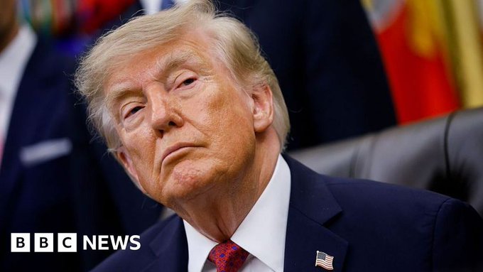 A close-up photo of Donald Trump in a dark suit with a red tie and American flag pin, shown with the 'BBC NEWS' watermark in the lower left corner.
