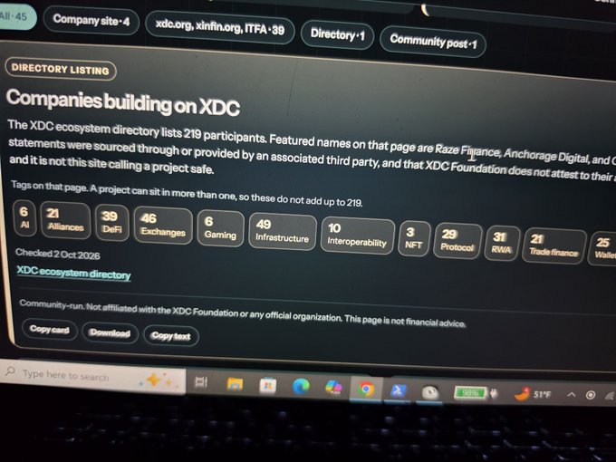 A photograph of a laptop screen displaying a webpage titled 'Companies building on XDC' with a directory listing 219 participants across categories like AI, DeFi, Gaming, and Infrastructure, checked on '2 Oct 2026'.