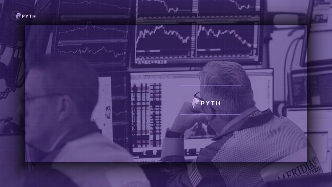 The image features two men sitting at desks, one of whom appears to be using a computer screen displaying stock market data. The other man has his hand over his mouth, possibly reacting to something he sees on the screen or discussing with someone else nearby. The background shows multiple monitors and screens displaying various stock prices and charts, indicating that they are in a financial setting.