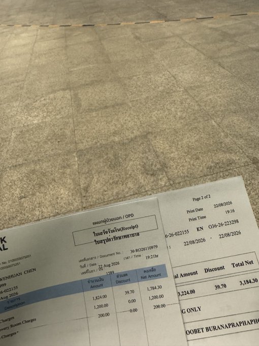 A faded receipt resting on a tiled floor shows charges from Bangkok Hospital Phuket dated 22/08/2026, with itemized costs including a pharmacy charge of 1,824.00 and a total net amount of 3,184.30—humorously illustrating the steep "transaction fees" of a day-trading crypto spree that landed the poster in the hospital.