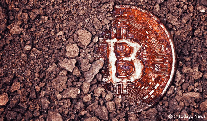 A close-up photograph of a copper-colored Bitcoin partially buried in reddish-brown soil and dirt, with a watermark reading '@Todayq_news' in the bottom right corner.
