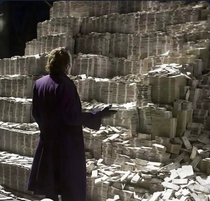 A person in a dark robe stands before massive stacks of bundled cash, symbolizing immense wealth and financial success. This imagery visually reinforces the post's bullish outlook on Litecoin ($LTC), suggesting that the impressive 300M testnet transactions signal substantial monetary gains ahead once mainnet adoption takes hold.