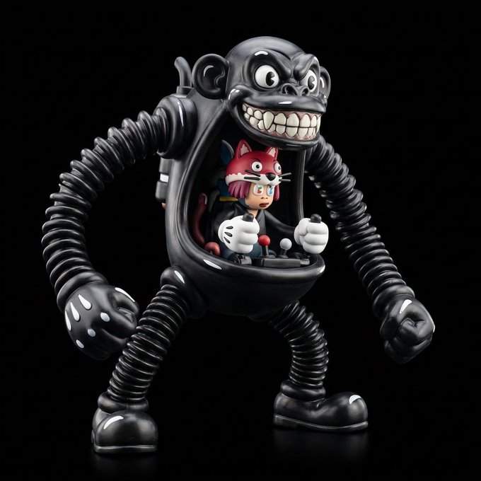 A designer vinyl/art toy figure featuring a large black gorilla-like mech suit with a grinning face, containing a smaller character with pink hair and a red fox inside its chest cockpit.