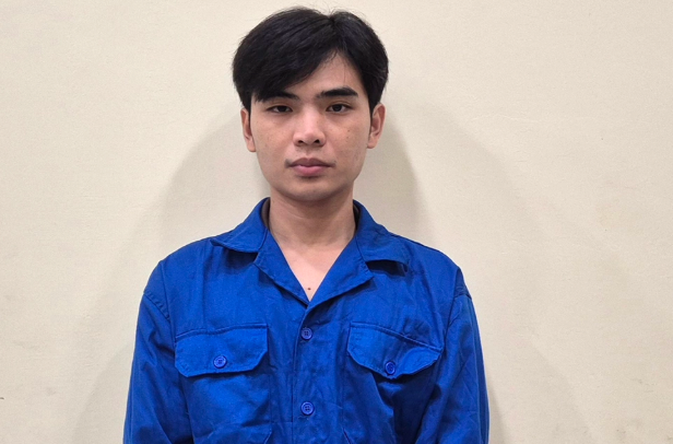 A young man with dark hair wearing a blue button-up shirt stands against a plain beige wall, his neutral expression reflecting the serious consequences of his actions as described in the accompanying post about his financial ruin and criminal downfall.