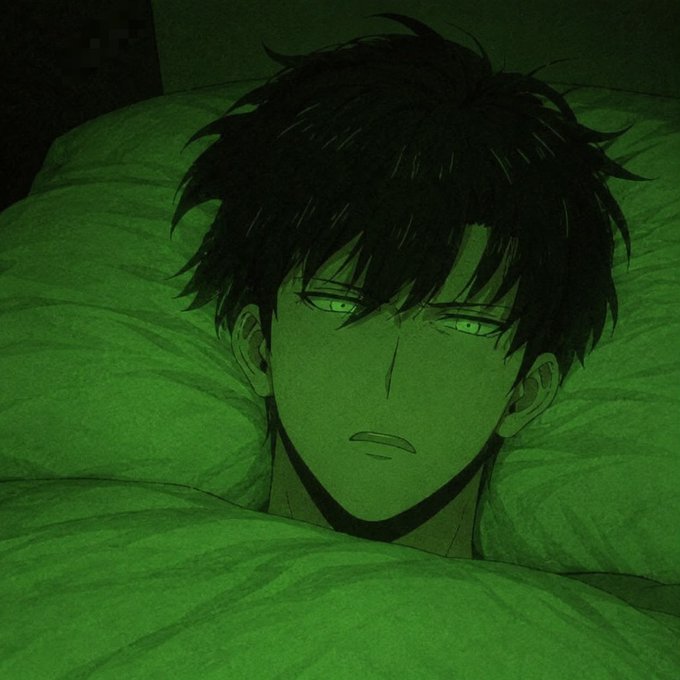 An anime-style illustration shows a young man with dark hair lying in bed bathed in eerie green lighting.