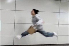 A blurry action shot of a person mid-stride running or lunging across a white tiled floor while holding a brown paper bag.