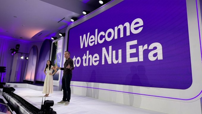 Two presenters stand on a stage in front of a massive purple screen displaying "Welcome to the Nu Era," as Nu announces the integration of $CRCL stablecoins into its new multi-currency digital account, marking a significant step for the platform serving over 140 million customers worldwide.