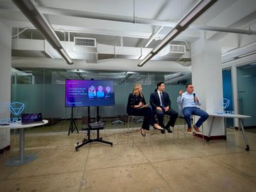 Three panelists sit on stools discussing institutional finance and blockchain security at CertiK's NYC Open House, with a presentation screen displaying "GLOBAL CONNECTION" and XDC Network branding behind them, illustrating the collaborative conversation about bringing institutional finance onchain.