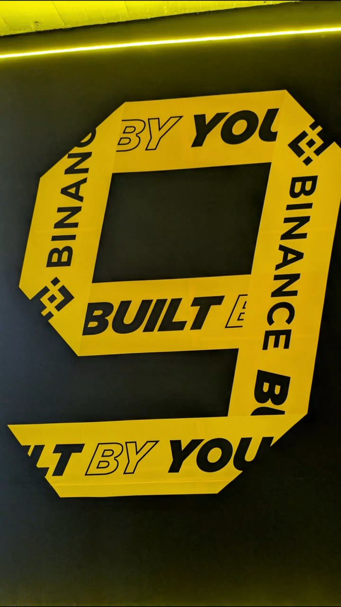 A black and yellow logo design features a large '9' shape with text reading 'BUILT BY YOU' and 'BINANCE' repeated around it.