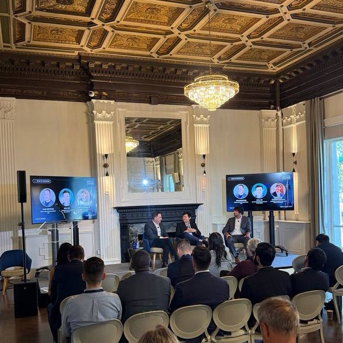 The image captures a panel discussion at The Digital Chamber's Convergence Forum in NYC, featuring GSR and BlackRock representatives seated on stage in an ornate, gilded venue with a crystal chandelier, while two screens display headshots of additional speakers, reflecting the post's focus on stablecoins and the future of onchain capital markets.