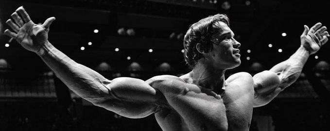A muscular man flexes his arms outward in a dramatic black-and-white photo, evoking power and determination as a metaphor for the strength needed to succeed in 2027 through strategic crypto focus on variational, pacifica, and extended markets. The accompanying post advises readers to grind now and hedge with newer perps to make winning easy for everyone putting in the effort.