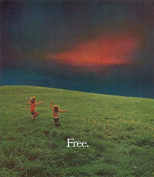 Two children run through a grassy field dotted with yellow flowers under a dramatic dark sky with a striking red cloud formation, with the word 'Free.' written in white text.