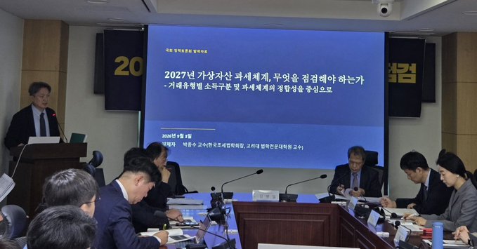 The image shows a seminar titled "2027 가상자산 과세제계, 무엇을 점검해야 하는가 - 거래유형별 소득구분 및 과세체계의 정합성을 중심으로" (What should be examined regarding the 2027 virtual asset taxation system - Focusing on the consistency of income classification and taxation system by transaction type), held on March 19, 2024, at the National Assembly, where tax law experts are discussing cryptocurrency taxation issues—directly relevant to the post highlighting concerns about delayed coin taxation and tax fairness with Korean stocks raised by Park Jong-su.