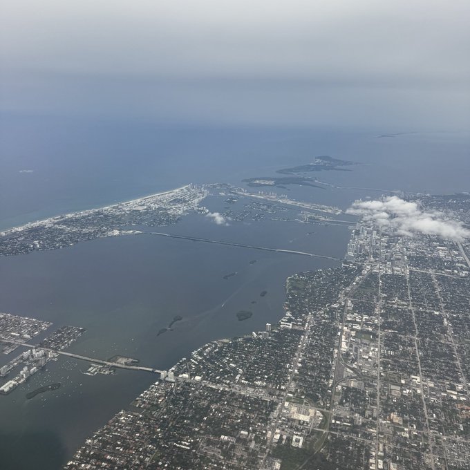 An aerial view of a coastal city with bridges spanning across a bay, likely showing a tropical or subtropical region.