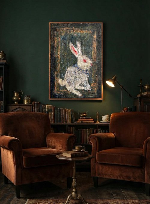 Two brown velvet armchairs sit in a dimly lit room before a bookshelf and a painting of a white rabbit against a dark green wall.