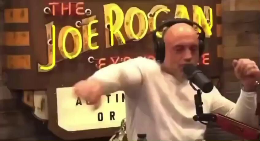 The image features a man wearing headphones, standing in front of a microphone with his arms outstretched as if he's dancing or singing into it. The background includes a neon sign that says "THE ROCAN" and another sign that reads "BITCOIN IS ON SALE BUY THE DIP!!!". This suggests that the image is related to a post about buying Bitcoin, possibly promoting an online cryptocurrency exchange service.

The man's position in front of the microphone with his arms outstretched adds a sense of energy and excitement to the scene, which could be interpreted as him singing or dancing along to the Bitcoin advertisement. The neon signs behind him further emphasize the theme of digital currency and online transactions.