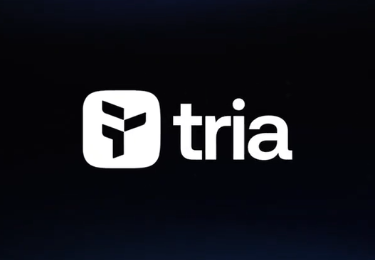 The image features a logo of the company Tria that is displayed against a black background. The logo consists of a white square with a stylized "F" at its center, which represents the company's name. The text "Tria" is written in white letters below the logo, and it appears to be a part of an advertisement or promotional material for the company.