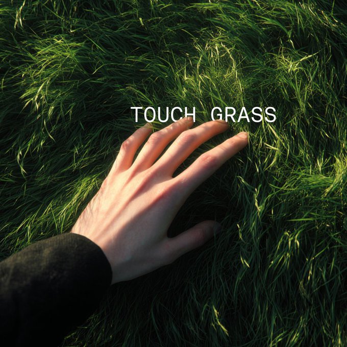 A hand touches lush green grass with the text "TOUCH GRASS" overlaid, serving as a visual reminder of the common internet slang urging people to step away from their screens and reconnect with the real world.