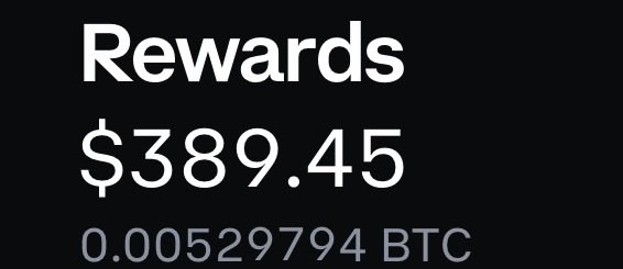 The image shows a black and white text box containing information about rewards, with "REWARDS" printed in large white letters at the top of the box. Below this are two numbers, $3889.49, and a "0.01" symbol that could represent 0 Bitcoins or any other type of currency used for the reward.