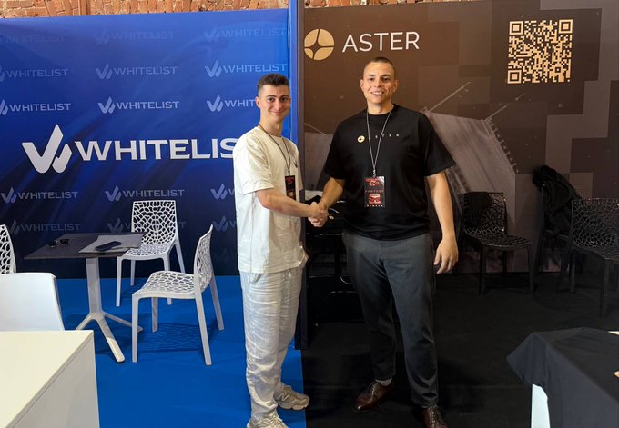 Two men shake hands at a conference booth, with the "WHITELIST" and "ASTER" branded backdrops visible behind them, capturing the in-person meeting between Whitelist Media and the Aster DEX team mentioned in the post.