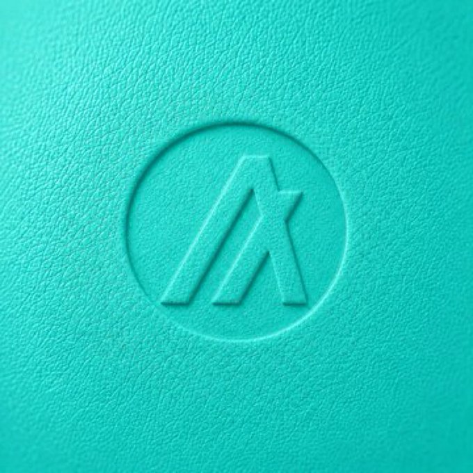 The image features a close-up view of a blue surface with an "A" logo prominently displayed within a circle. The logo appears to be made from a material that resembles leather or plastic, giving it a unique texture. The background color is a light blue, which contrasts nicely with the darker blue of the logo and the text in the image.