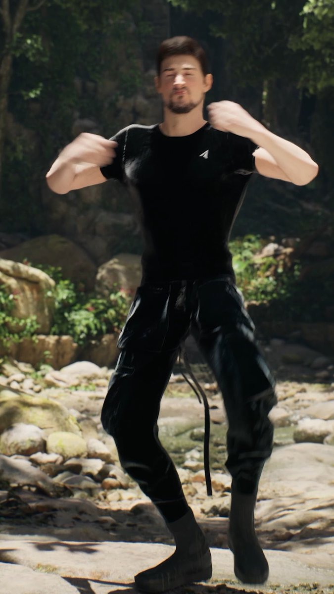A man in all black athletic wear stands on rocky terrain with his fists raised in a fighting stance, appearing slightly blurry.