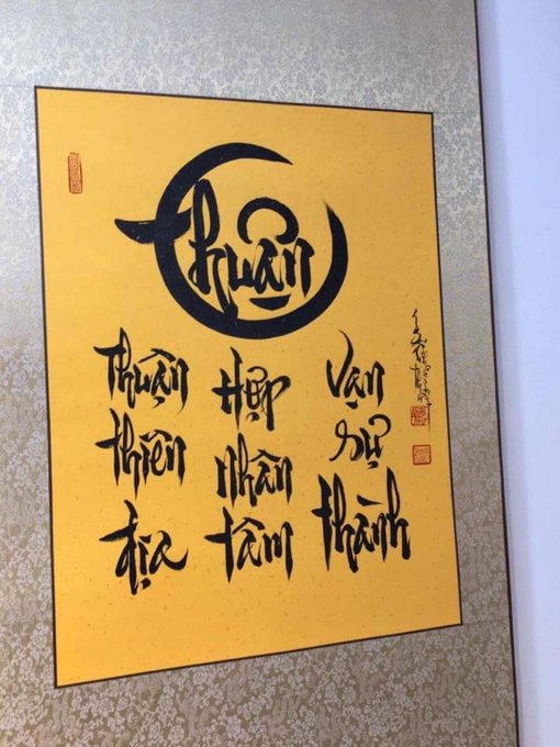 Traditional Vietnamese calligraphy artwork on yellow paper featuring stylized "Thuận" text within a circular design along with additional calligraphy characters and red stamps.