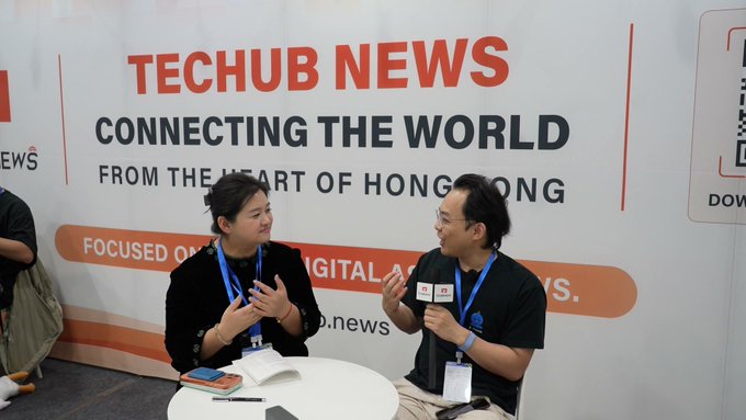 Two men sit at an interview table for "TECHUB NEWS - CONNECTING THE WORLD FROM THE HEART OF HONG KONG", focused on digital news.