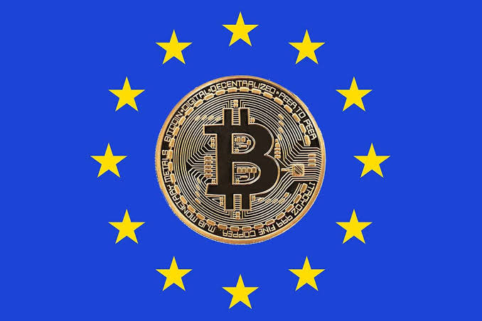 A gold Bitcoin coin is superimposed over the European Union flag, featuring its blue background and circle of yellow stars.