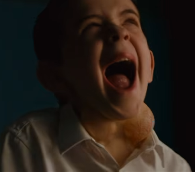 A close-up photograph shows a man in a white collared shirt screaming with his eyes closed and mouth wide open, appearing to be in distress or anguish.