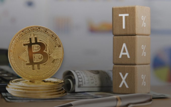 A golden Bitcoin coin rests beside a roll of $100 bills and wooden blocks spelling "TAX %" in the image. The visual ties directly to the post's theme, illustrating how cryptocurrency gains can be inflated by missing transaction data, resulting in higher-than-expected tax liabilities.