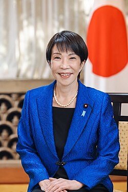 The image shows a Japanese woman in a blue suit, with the Japanese flag in the background, visually representing the "JAPAN LEADS THE WAY" sentiment of the accompanying post about financial transformation driven by XRP and crypto.