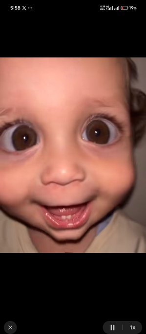 A close-up selfie of a smiling baby with big brown eyes and a playful expression fills the screen, while the status bar shows the time as 5:58 and battery at 19%. The cheerful image contrasts with the post's text about productivity achievements, including posting an educational thread about Zentrix and engaging with ActionFi's launch.