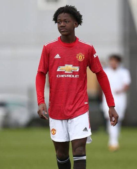 A young footballer wearing a red Manchester United jersey with "CHEVROLET" sponsorship stands on the pitch, representing the club's youth development system. The image's accompanying caption "BITCOIN 2010" suggests a comparison to early-stage potential—evoking how an emerging player, like Bitcoin in 2010, holds untapped promise before mainstream recognition.