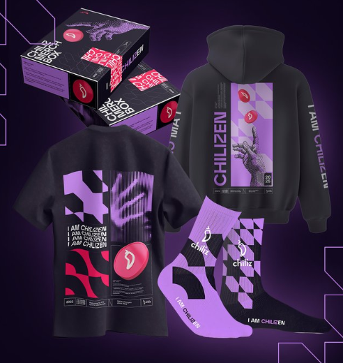 A merchandise display featuring "Chiliz" branded apparel including a black hoodie, t-shirt, and socks in purple and pink with "I AM CHILIZEN" text and the Chiliz logo.