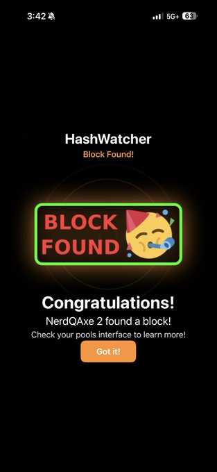 The image shows a black cell phone screen that displays information about finding a block hash. The background of the photo is black, making the white text and lighted neon sign stand out prominently. The post congratulates users who have successfully found the block hash, stating "Congratulations NerdQube! Block finally found." The post also provides instructions on how to navigate through pool software to find blocks that have been blocked by a previous user, suggesting that the HashWatcher tool has been utilized effectively in clearing their name.