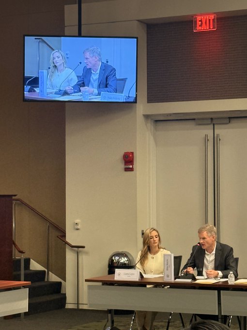 BitGo CEO Mike Belshe speaks at a CFTC Innovation Advisory Council Meeting in Washington, D.C., as shown on a monitor displaying the panel alongside his seated co-panelist at the formal proceedings.