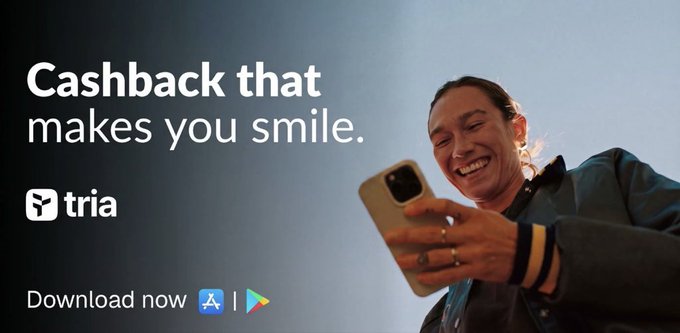 An advertisement for the 'tria' app featuring a smiling woman looking at her phone, with the tagline 'Cashback that makes you smile' and download options for the App Store and Google Play.