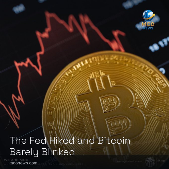 A graphic featuring a large golden Bitcoin coin against a dark background with a red price chart, bearing the text 'The Fed Hiked and Bitcoin Barely Blinked' from mconews.com and an 'MCO News' logo.