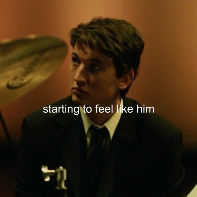 A still image of a young man in a dark suit and tie looking sideways with the text "starting to feel like him" overlaid in white, with a shower scene visible in the background.