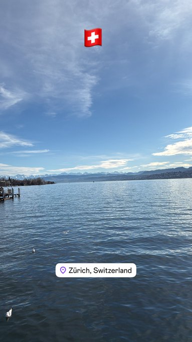 A scenic view of a lake in Zürich, Switzerland, with a Swiss flag emoji and location tag overlay.
