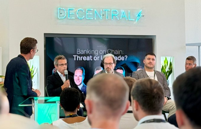 A panel discussion titled 'Banking on Chain: Threat or Upgrade?' taking place at a 'DECENTRAL' event, with four men seated on stage addressing an audience.