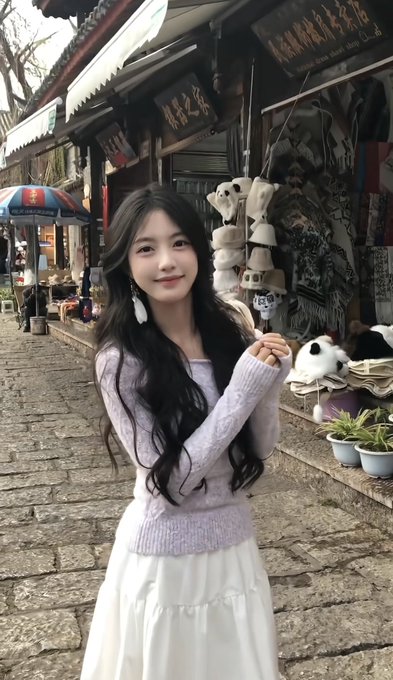A young woman with long dark hair wearing a lavender knit sweater and white skirt poses on a cobblestone street in front of a souvenir shop selling panda-themed items, with a sign reading "大理旅游工艺品" (Dali Tourism Crafts).

**Context note:** The accompanying post—advertising "local escorts" for companionship services—is a common scam/spam format often paired with AI-generated or stock images of attractive young women. The image appears unrelated to any legitimate service and should not be taken as a genuine representation of the person or any business. Be wary of such posts, as they frequently involve fraud or exploitation.