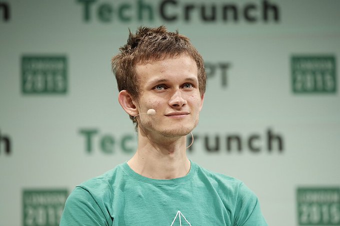 A young man wearing a teal t-shirt and a headset microphone stands on stage in front of a backdrop repeating the 'TechCrunch Disrupt 2016' logo.