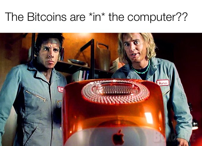 A meme captioned 'The Bitcoins are *in* the computer??' showing two confused-looking characters in blue jumpsuits staring at a Mac computer with its internal components glowing red.