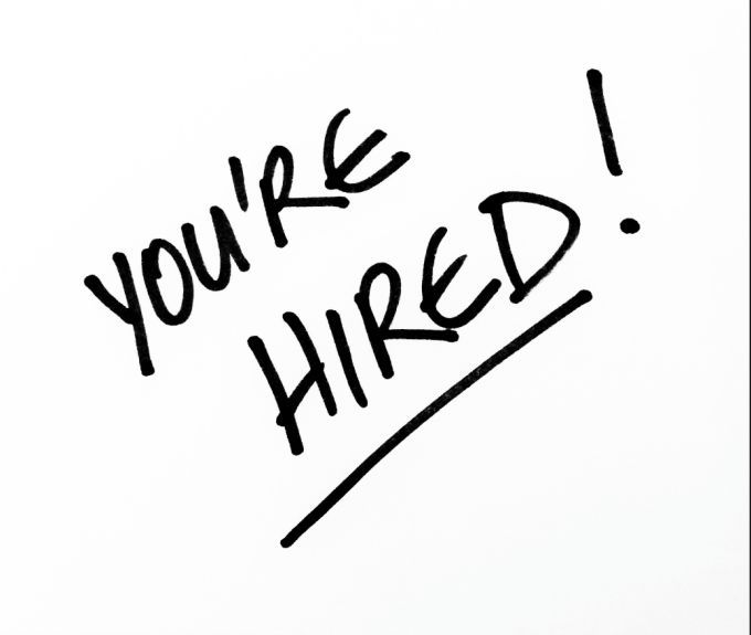 Hand-drawn handwritten text reading "You're HIRED!" with an underline, presented like a celebratory note.