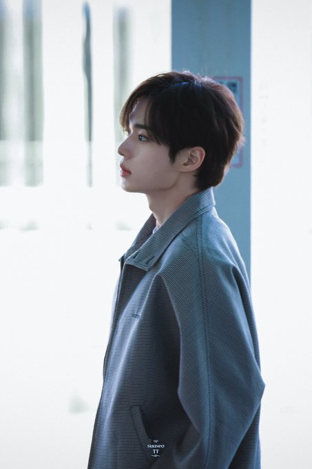 A young man with brown hair is shown in profile, gazing upward while wearing an oversized denim jacket featuring the "SHUSHU/TONG" label. The image aligns with the post's hashtags, which reference an August 12, 2026 Incheon event for Alpha Drive One member Junseo.