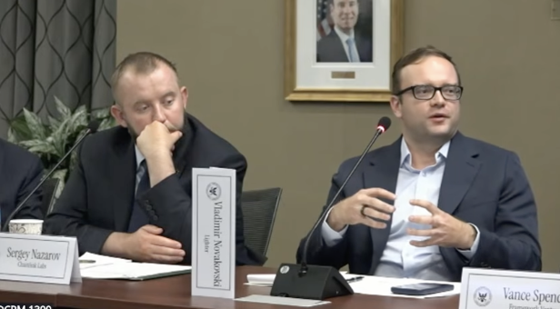 Two men sit at a table in a panel setting, with nameplates for "Sergey Nazarov, Chainlink Labs" and "Vance Spencer" visible, along with a Vladimir Voskresenskii placard.